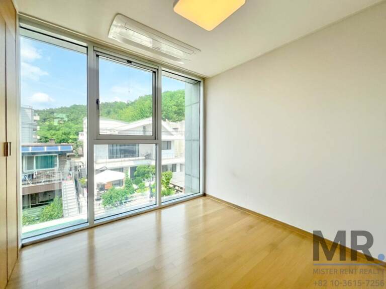 Bright bedroom with corner glass windows and hillside view