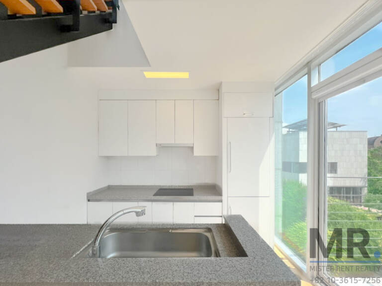 White kitchen with granite counter, sink and windows on the side