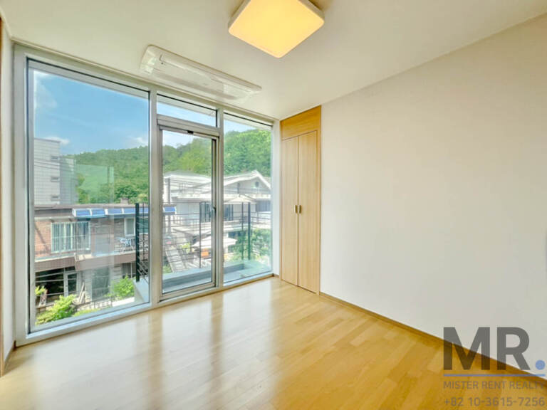 Bedroom with floor-to-ceiling window and wooden wardrobe