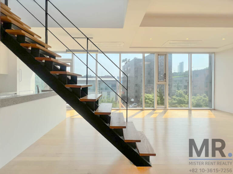 Open-tread steel staircase rising from the living room to the rooftop