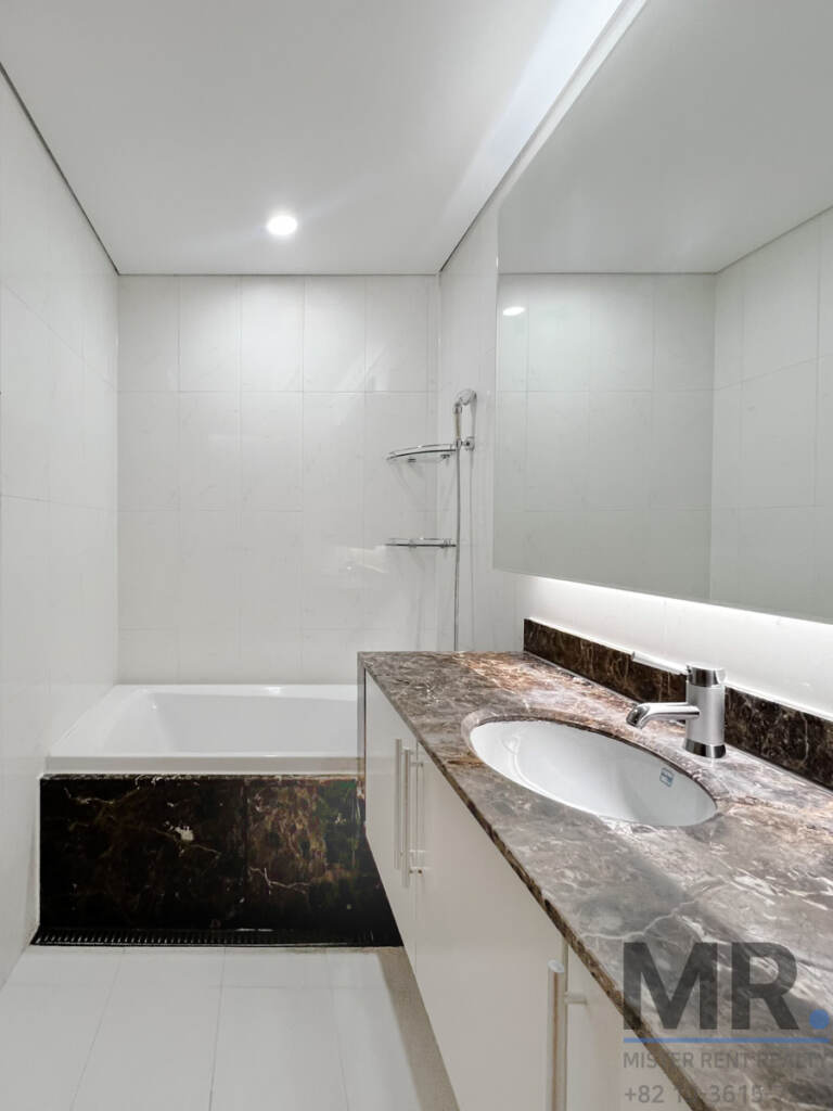 Bathroom with marble vanity and built-in bathtub