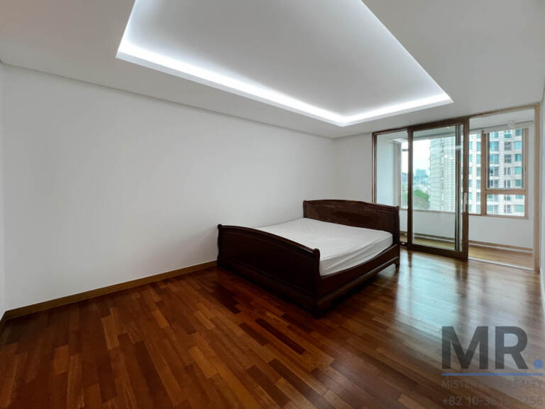 Bedroom with wooden bed and sliding doors to an enclosed balcony