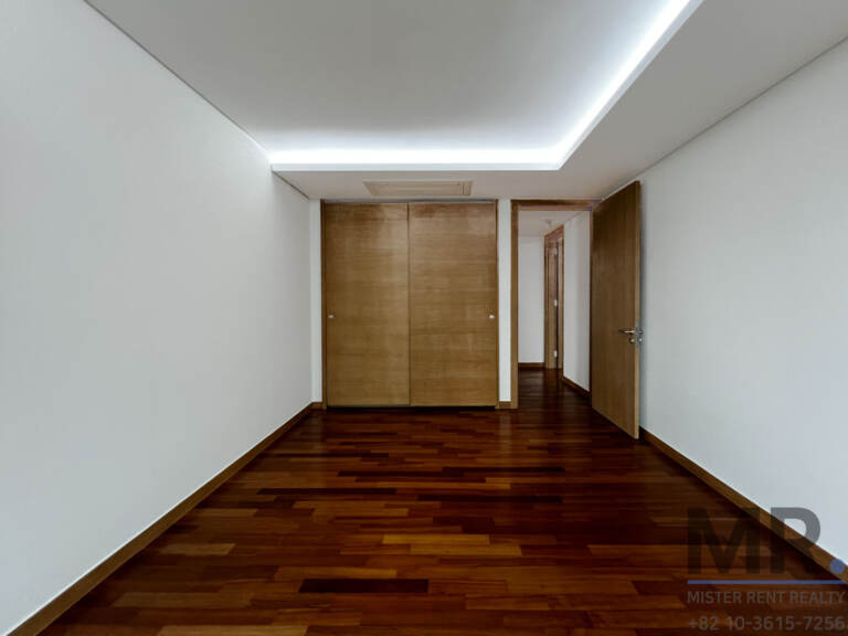 Bedroom with wooden built-in closet and cove-lit ceiling