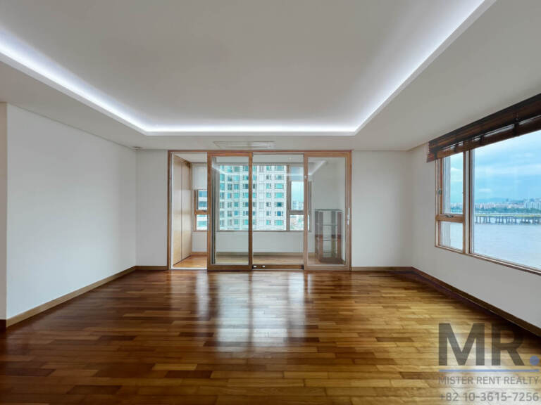 Corner room with glossy wood floor and sliding doors to a sunroom