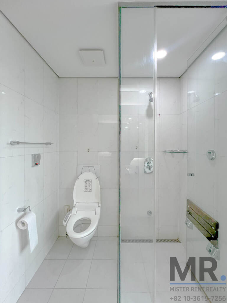 White-tiled bathroom with glass shower stall