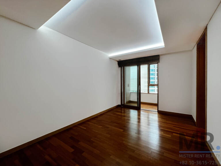 Bedroom with hardwood floor and window with roller blind