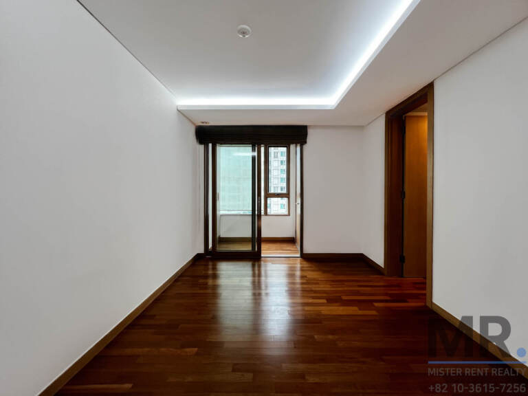 Room with cove ceiling lighting leading to a balcony