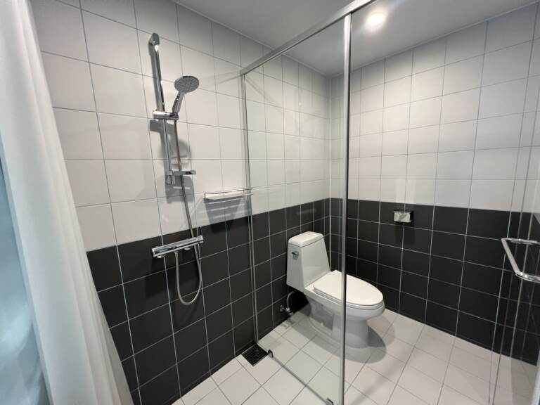 Bathroom with glass shower partition and black-and-white tiles