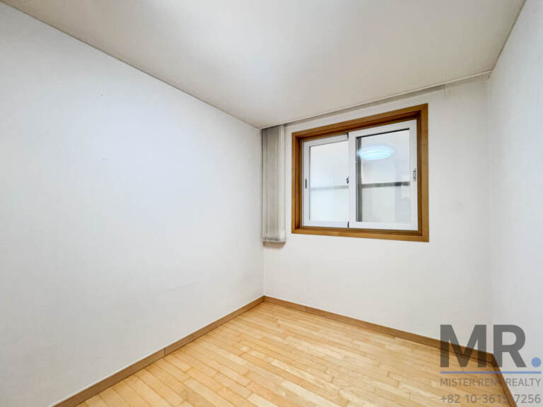 Small bedroom with wood-framed window