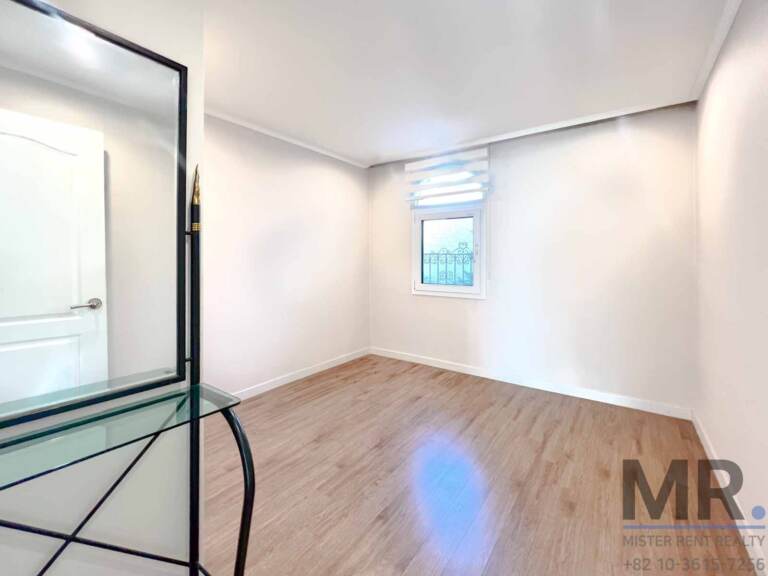Small bedroom with glass desk and window with blinds