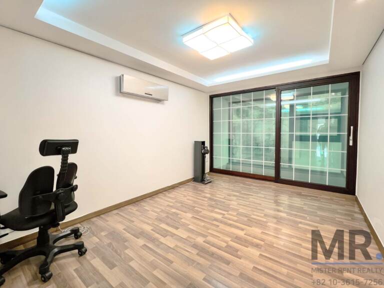 Bedroom with large grid-pane windows and wall-mounted air conditioner