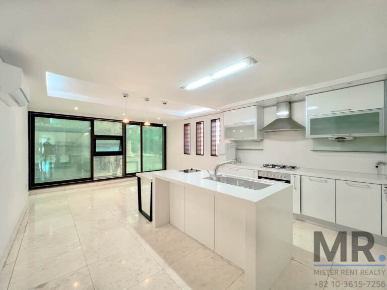 Kitchen and dining area with marble floor, white island and floor-to-ceiling windows