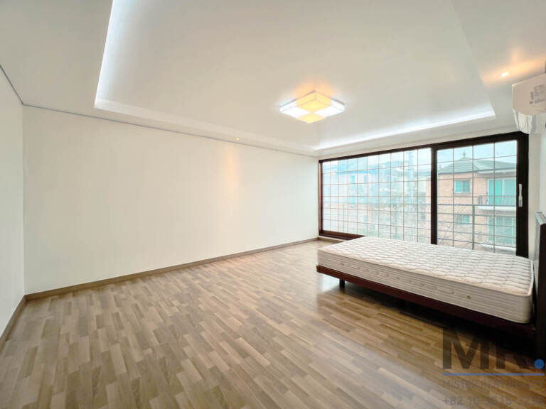 Master bedroom with corner windows overlooking neighboring houses