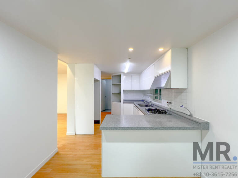 White kitchen with grey stone counter and gas range