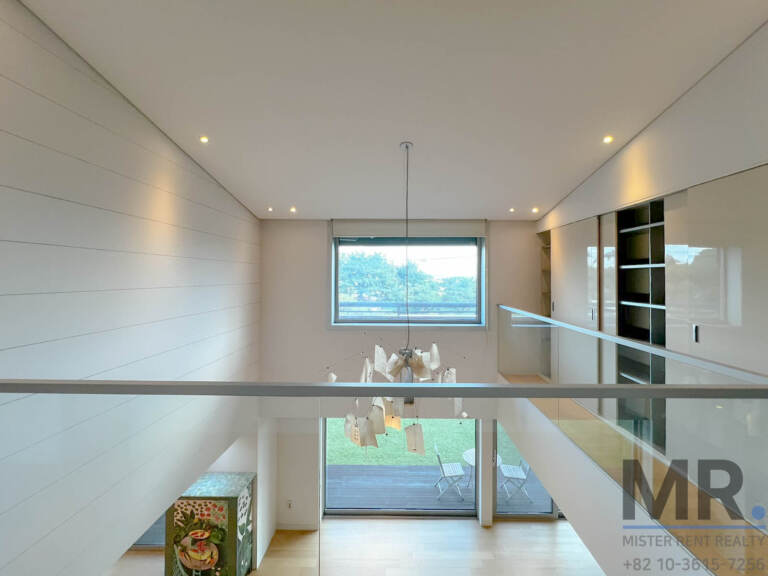 View from the upper-floor landing over the double-height living room and garden