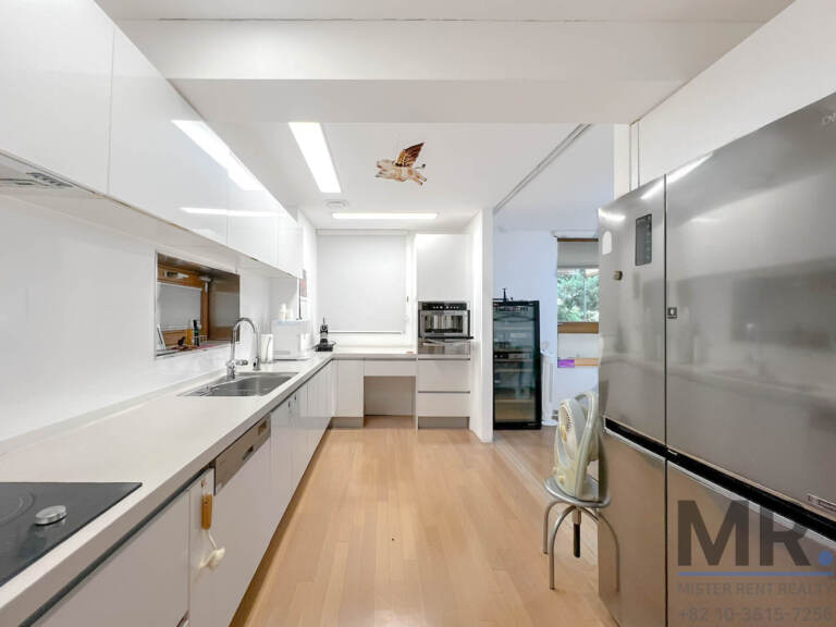 Galley kitchen with white counters, built-in oven and wine fridge
