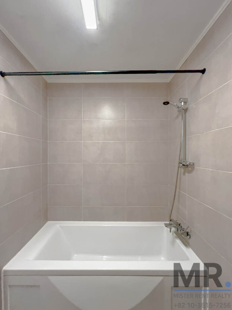 Bathroom with bathtub and beige wall tiles