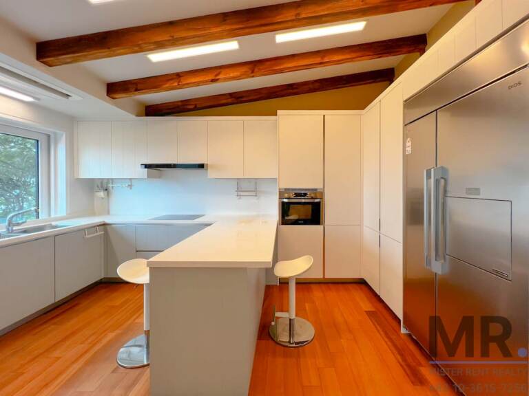 Kitchen with breakfast bar, built-in oven and stainless steel refrigerator