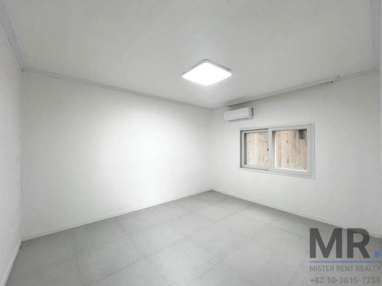 Plain bedroom with small window and air conditioner