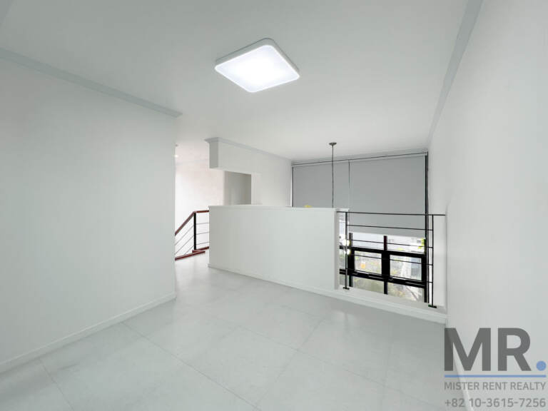 Upper floor landing with stair railing and roller-blind windows