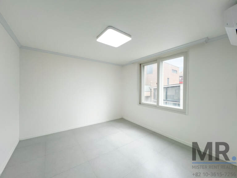 Bright bedroom with corner window and white walls