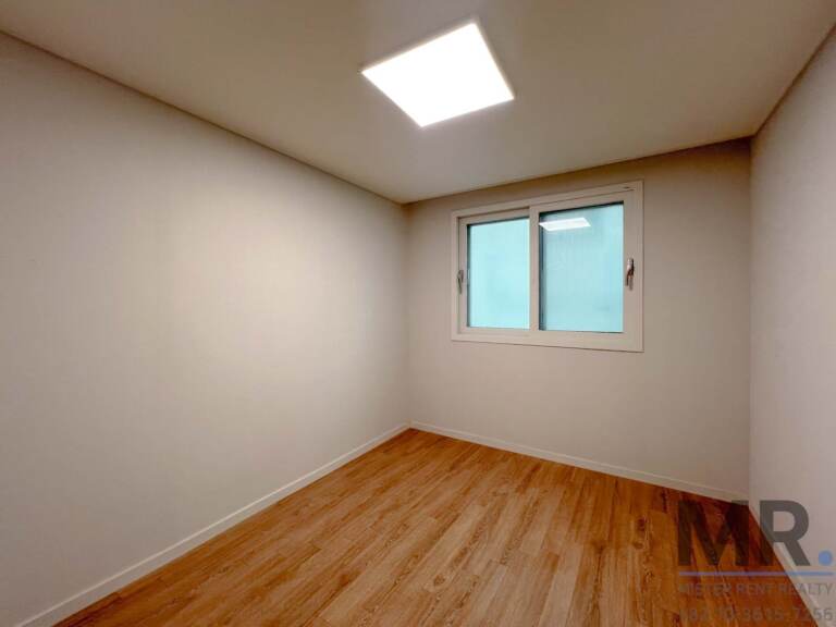 Bedroom with warm wood floor and single window