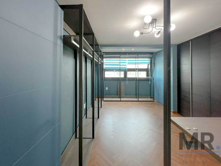 Walk-in dressing room with open clothes racks and dark wardrobes