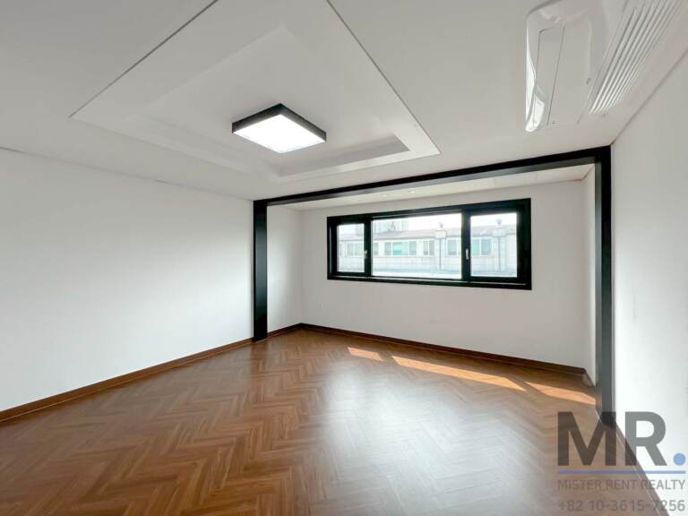 Bedroom with tray ceiling, wall air conditioner and sunlit wood floor