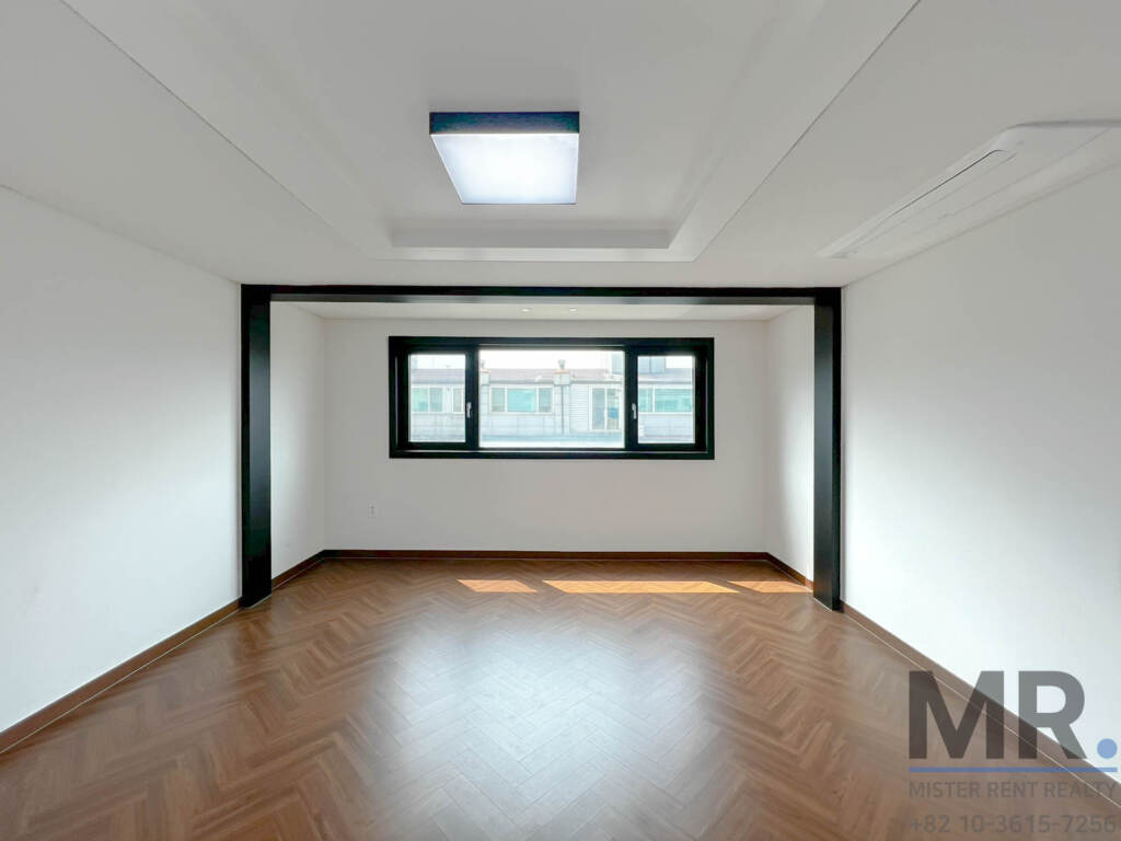 Bedroom with herringbone wood floor and framed window niche