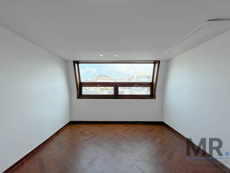 Top-floor bedroom with dormer window and herringbone floor