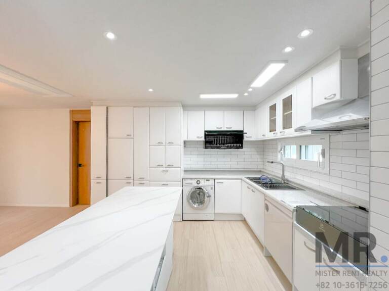 White kitchen with marble-look island, subway tiles and washing machine
