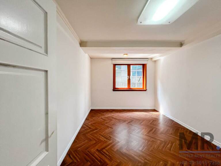 Small bedroom with window and herringbone floor