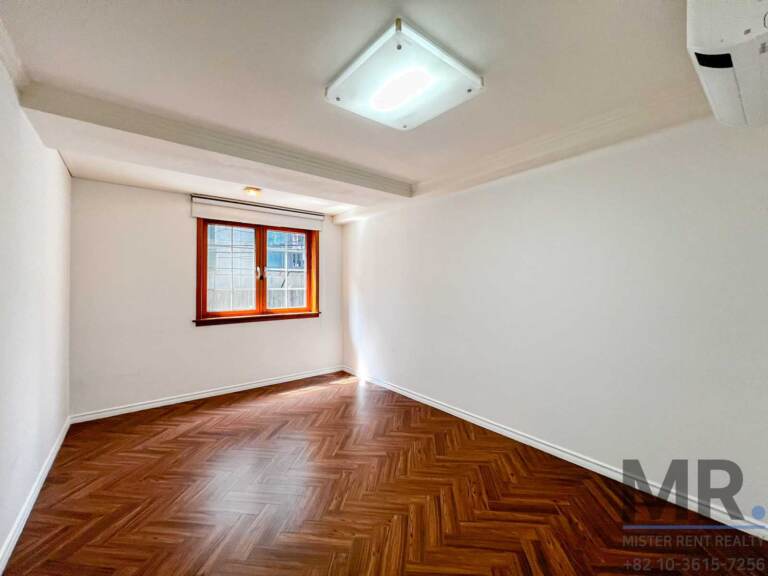 Bedroom with wood-frame window and air conditioner