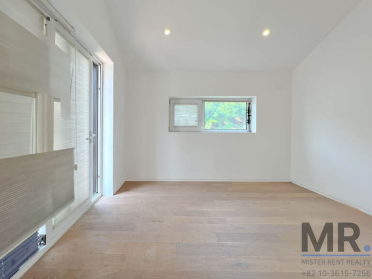 Room with pitched ceiling, tall glass door and small window