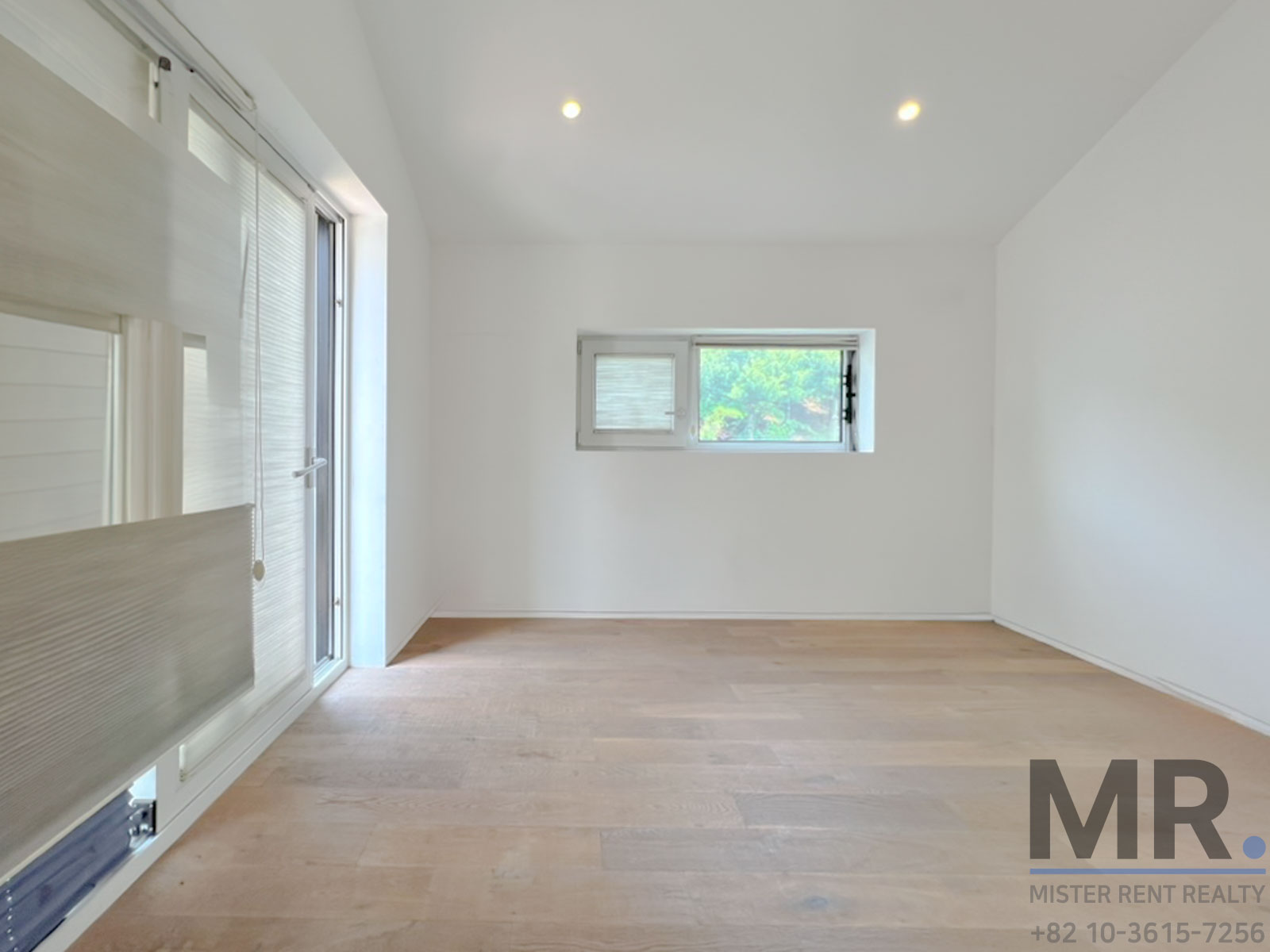 Bright, empty room with wooden floor.