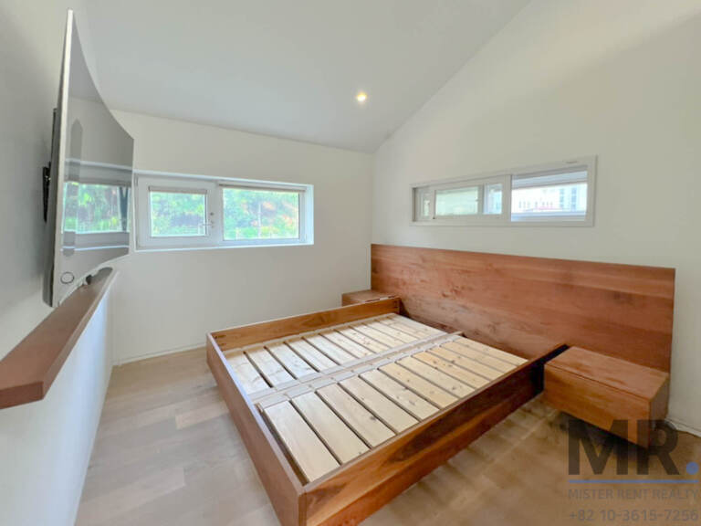 Attic bedroom with walnut platform bed and sloped ceiling