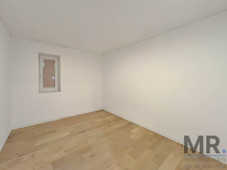 Empty room with light oak floor and small window