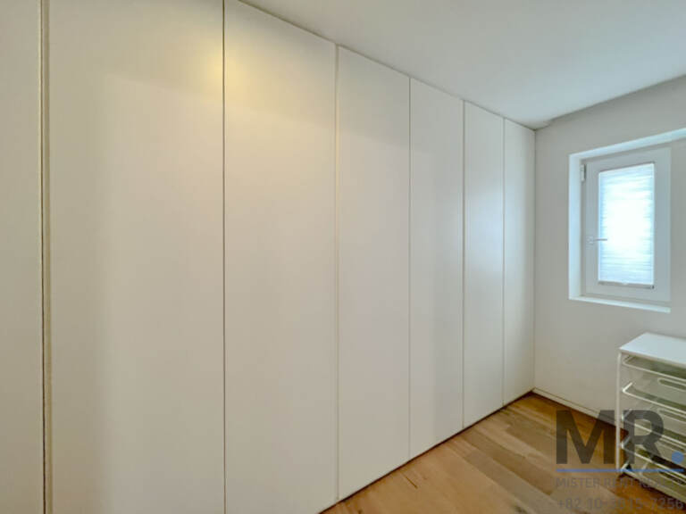 Room with full wall of white built-in closets