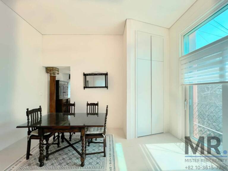 Dining nook with antique wooden table and tall built-in cabinet