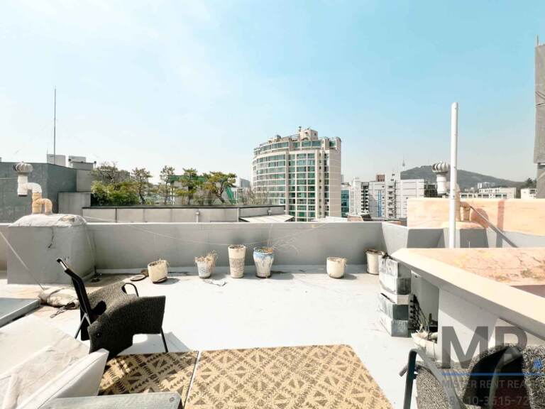 Private rooftop terrace with lounge chairs and city and mountain view