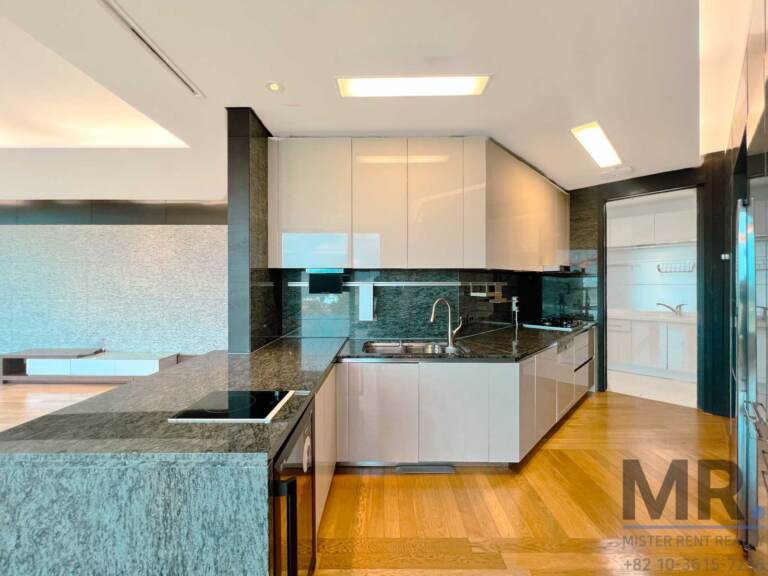 Kitchen with granite countertop, induction cooktop and white cabinets