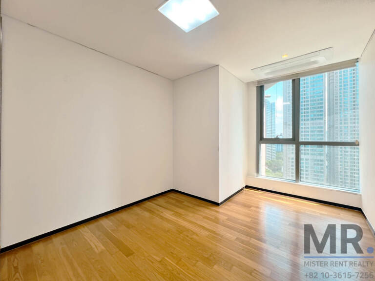 Small bedroom with oak floor and corner window