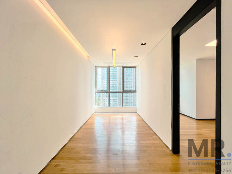 Corridor with cove lighting leading to a window