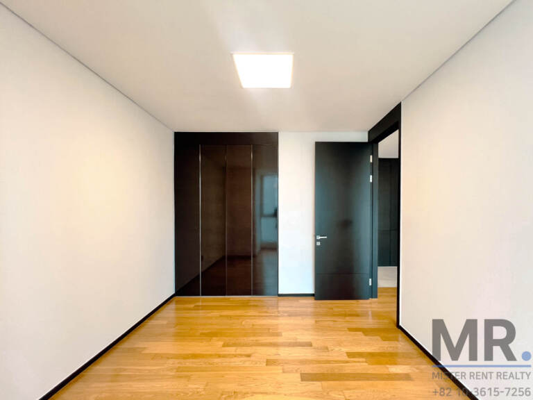 Bedroom with dark built-in wardrobe and oak flooring