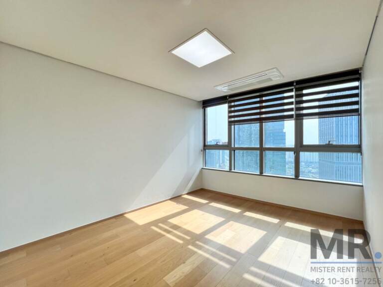 Bedroom with wide window overlooking high-rise buildings