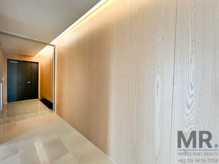 Foyer with wood-grain wall panels and dark front door