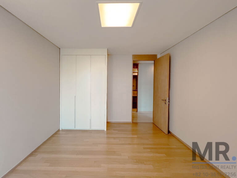 Bedroom with white built-in wardrobe and oak floor