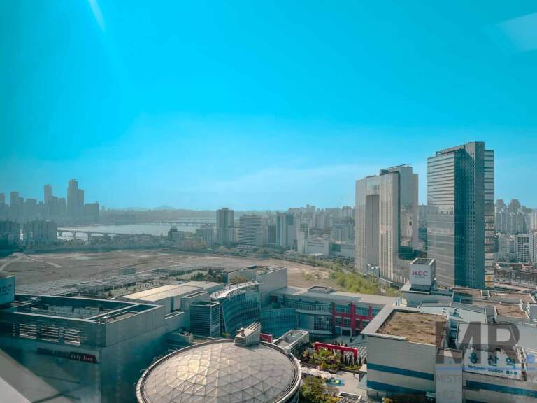 High-floor view over Yongsan Station toward the Han River and city skyline