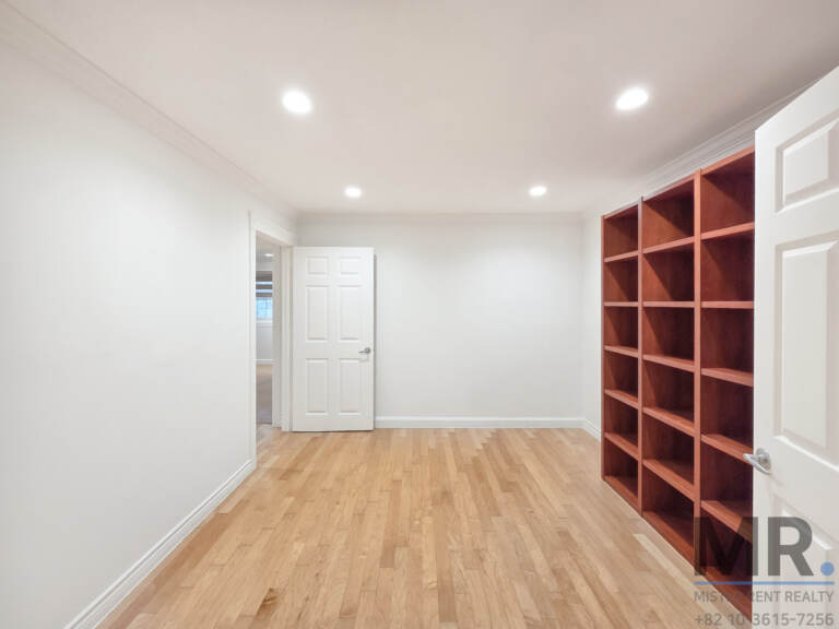 Room with wooden built-in bookshelves and hardwood floor