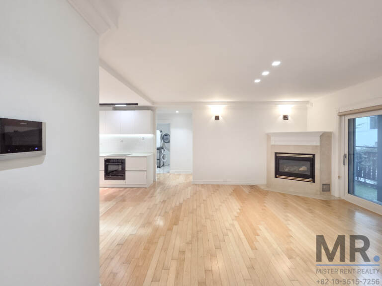 Open living area with fireplace and view to the white kitchen